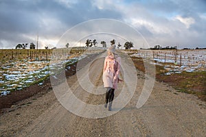 Woman walking down a country road in winter