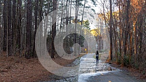 Woman walking down empty bath in woods