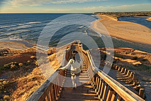 Woman walking down iconic Port Noarlunga boardwalk