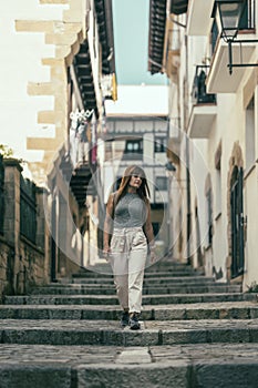 woman walking down a stone staircase street