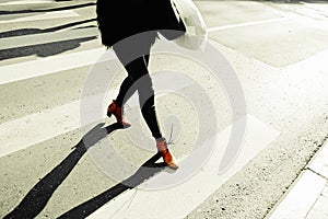 Woman walking downtown on the crosswalk\'s road