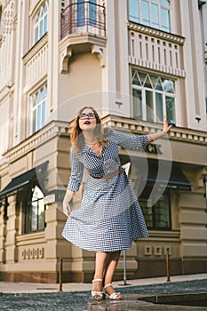 Woman walking in dress in old city. Fashion Style Photo Of A Young Girl. happy stylish woman at old european city street