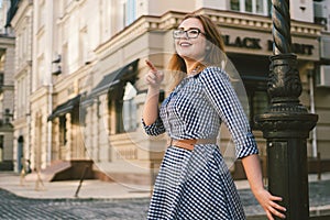 Woman walking in dress in old city. Fashion Style Photo Of A Young Girl. happy stylish woman at old european city street