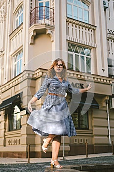 Woman walking in dress in old city. Fashion Style Photo Of A Young Girl. happy stylish woman at old european city street