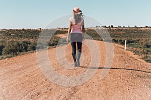 Woman walking dusty roads of outback Australia