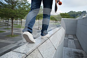 woman walking on the edge of a urban building wall at city