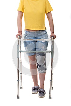 Woman with walking frame and knee orthosis