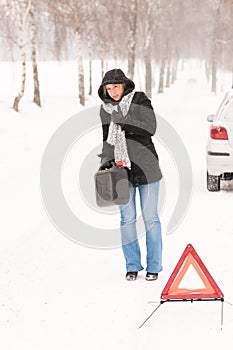 Woman walking with gas can car snow