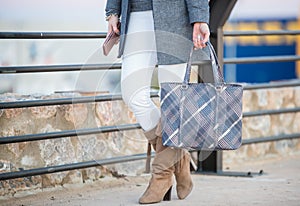 Woman walking with a gray plaid bag