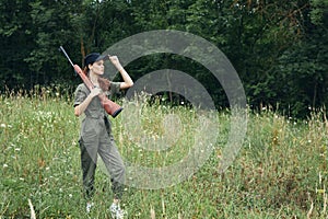 Woman walking with a gun in nature hunting lifestyle green overalls
