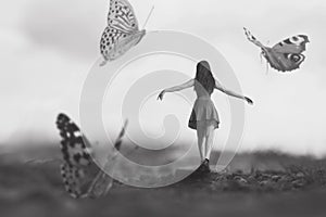 a woman walking happily among giant butterflies dancing around her, abstract concept