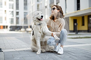 Woman walking with her big white dog on the street