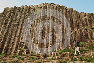 Woman walking among hexagonal stones at Giant`s Causeway