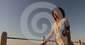 Woman walking and holding a skateboard on hand