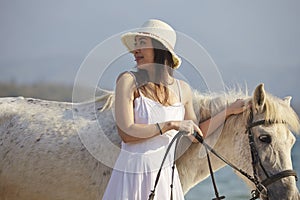 A woman walking horse on beach