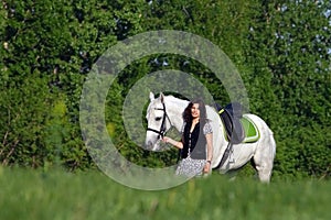 Woman walking horse in rural field