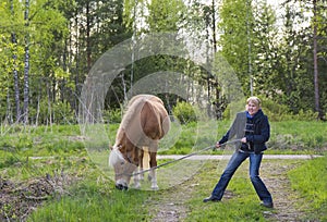 Woman walking with horse in summer in Finland