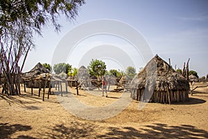 Woman walking between houses of the Karo tribe, southern Ethiopia, Omo Valley