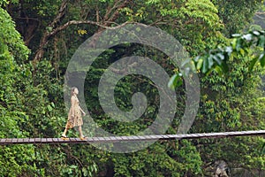 Woman walking on jungle bridge