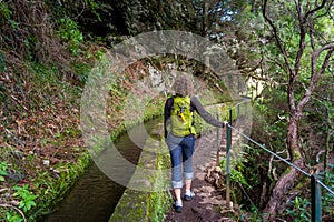 Woman walking on levada 25 fountains in Rabacal, Madeira island.