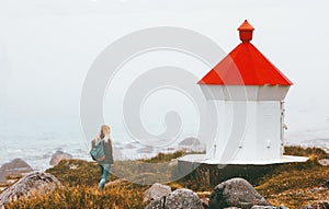 Woman walking at lighthouse foggy sea solo traveling