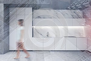 Woman walking in marble and concrete kitchen