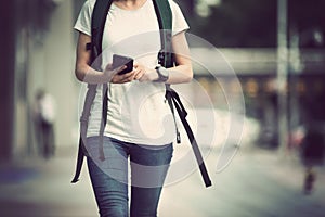 woman walking with mobile phone in modern city