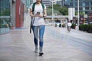 Woman walking with mobile phone in modern city