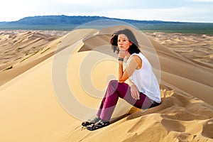 Woman walking in the mongolian desert sand dunes. Young woman walking golden sand on a bright summer day, Mongolia