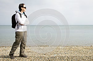 Woman walking next to the sea on pebble beach