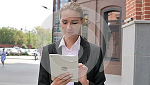 Woman Walking Ouside Office and Browsing on Tablet