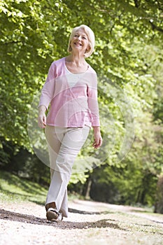 Woman walking outdoors smiling