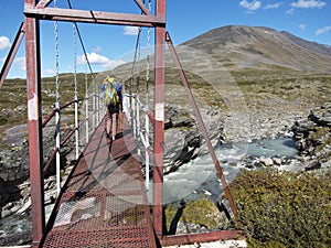 Woman walking over a bridge in swedish lapland