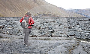 Woman walking over the new lavafield of the volcano eruption at Fagradalsfjall photo