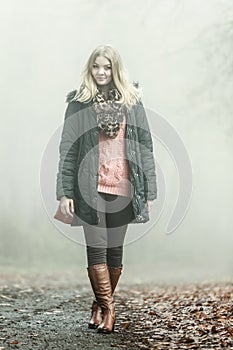 Woman walking in park in foggy day