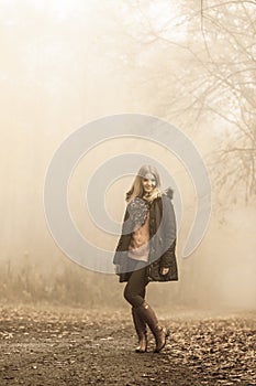 Woman walking in park in foggy day