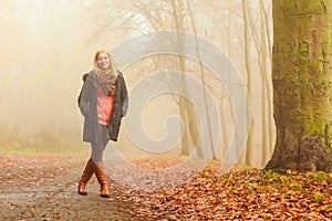 Woman walking in park in foggy day