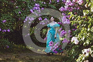 Woman is walking in the park of lilac.
