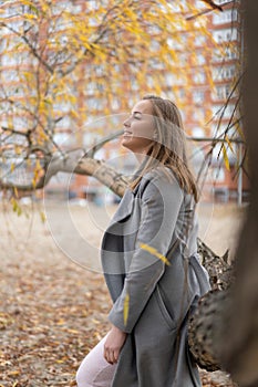 Woman walking in park wearing coat. Cold weather, autumn season