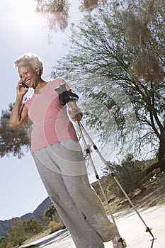 Woman With Walking Poles Using Cell Phone