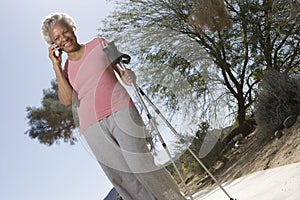 Woman With Walking Poles Using Cell Phone