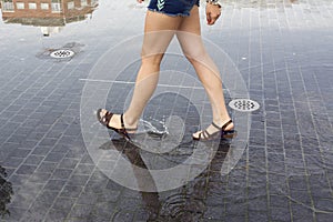 Woman walking on a puddle in the street photo
