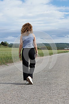 Woman walking on the road to the horizon