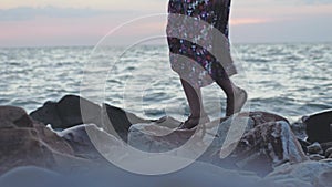Woman walking on rocky beach in slow motion in windy weather. 3840x2160