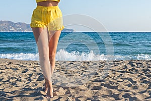 Woman walking on sand beach on a sunset. Travel, relaxation, positive emotions. Concept.