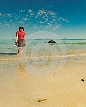 Woman walking on sandy beach, Lofoten Norway