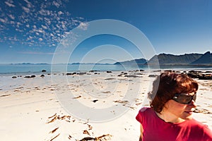 Woman walking on sandy beach, Lofoten Norway