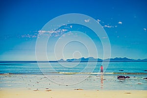 Woman walking on sandy beach, Lofoten Norway