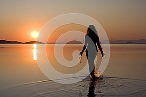 Una mujer en el mar sobre el atardecer 