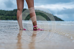 A woman walking in the shallows on the beach